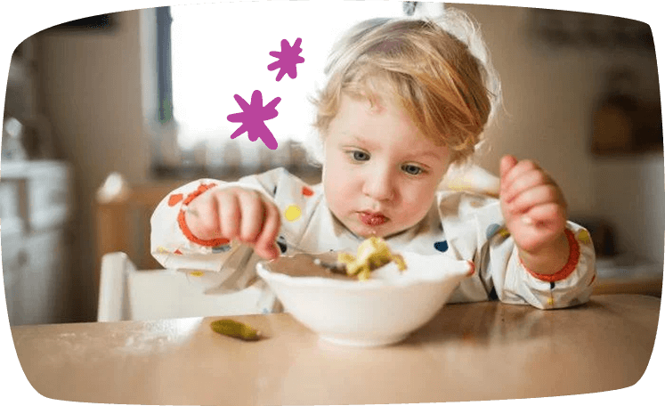 peuter wil zelf eten uit een bord