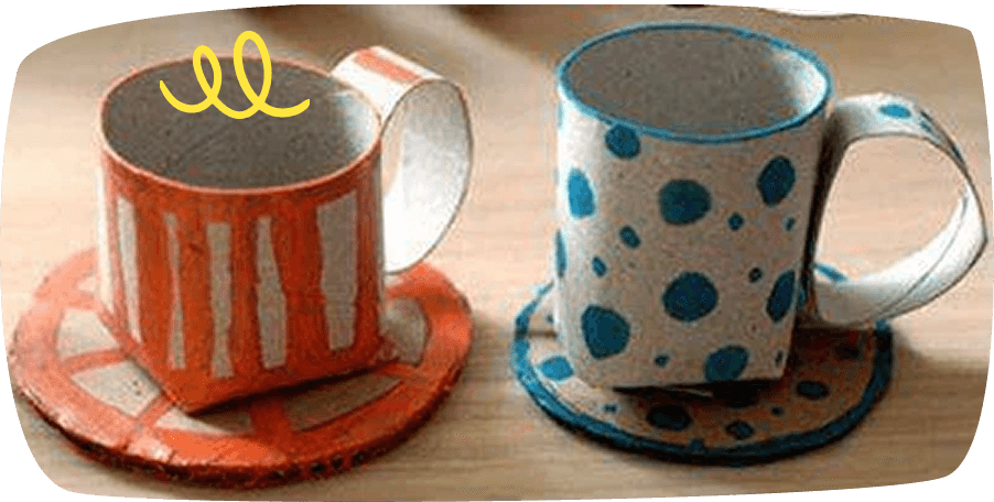 Two handmade ceramic mugs on saucers, one painted orange with white stripes and one white with blue polka dots.